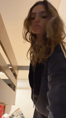Woman hangs from bunk bed bar in Mexican bedroom