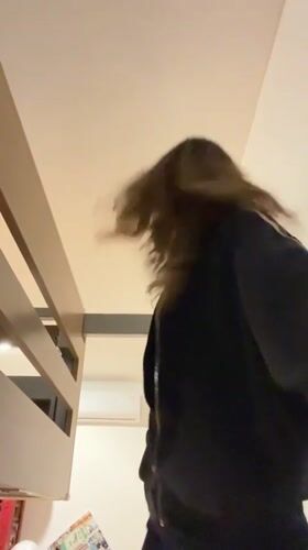 Woman hangs from bunk bed bar in Mexican bedroom