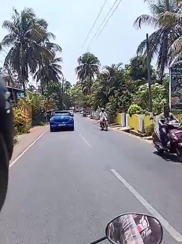 Morning motorcycle ride through palm-lined streets in Marna, India