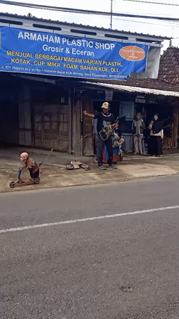 Motorcycle rider passes plastic shop, monkey rides scooter in Winong