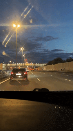 Evening highway drive through Kommunarka under a dusky sky