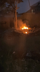 Nighttime fire burns in dirt lot in Bukuru, Nigeria
