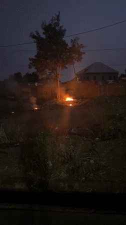 Nighttime fire burns in dirt lot in Bukuru, Nigeria
