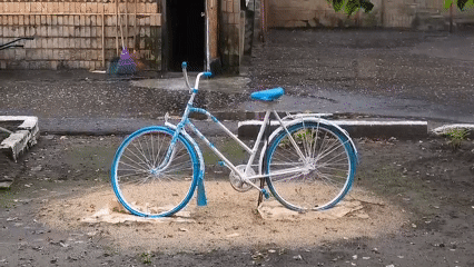 Decorated white and blue bicycle parked in a Mikhaylovka courtyard
