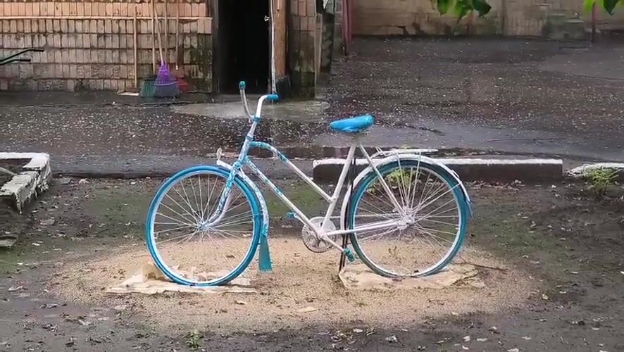Decorated white and blue bicycle parked in a Mikhaylovka courtyard