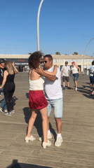 Group dances on Tel Aviv boardwalk near iconic city sign