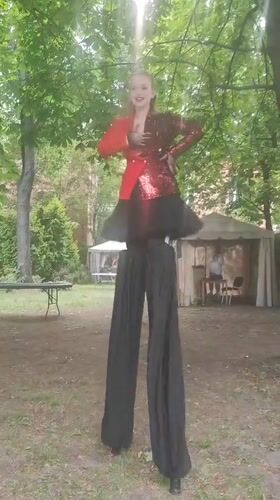 Busy Moscow afternoon: stilt performer, street crowds, outdoor cafes