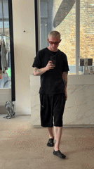Tattooed individual spotted in London retail area, street activity documented