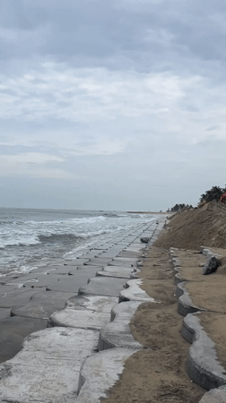Hoi An's concrete seawall holds the line on an overcast shore