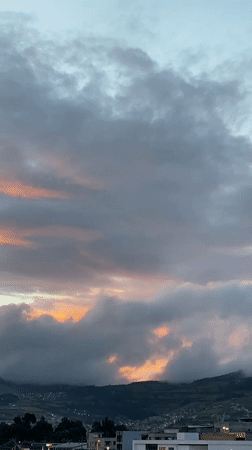 Twilight sky with crescent moon observed over Quito mountains