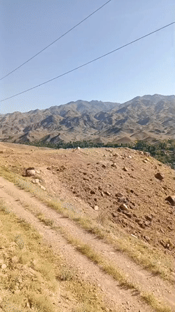 Panoramic views over an arid mountain valley and village below