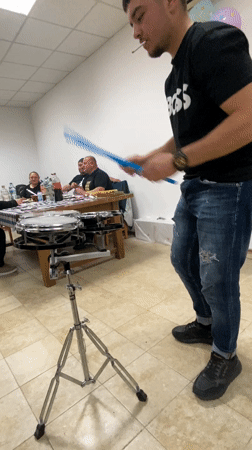 Young drummer performs with cigarette in Shkorpilovtsi room
