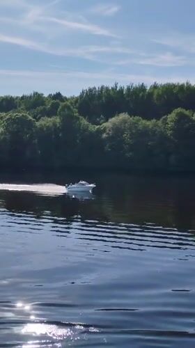 Motorboat crosses sunlit water near Novye Shatrishchi, Russia