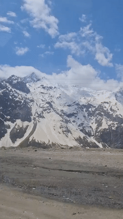 Snow-capped mountains filmed under blue skies in Tajikistan