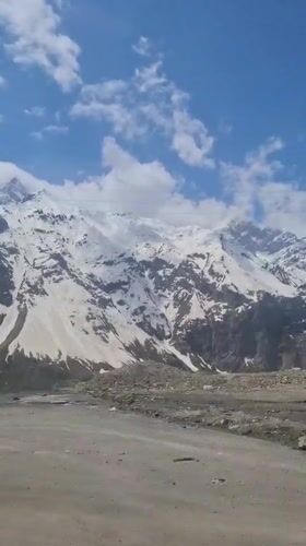 Snow-capped mountains filmed under blue skies in Tajikistan
