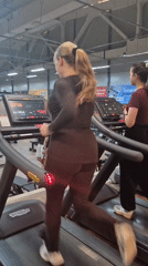 Woman films selfie video while running on gym treadmill