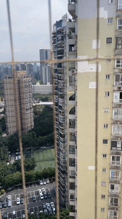 Morning cityscape viewed through security grating in Chongqing