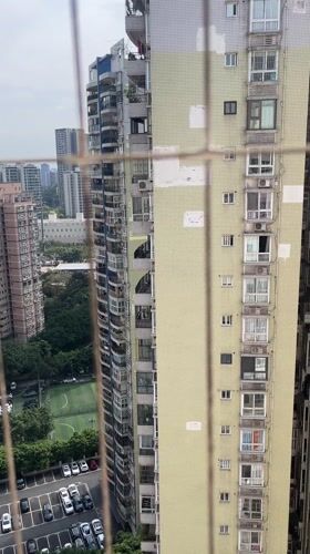 Morning cityscape viewed through security grating in Chongqing