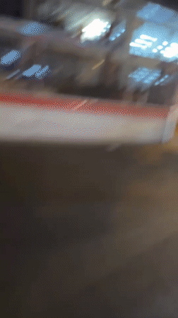 Two motorcycles pass through nighttime Paris street near construction