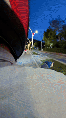 Motorcyclist rides decorated road in Fethiye at dusk
