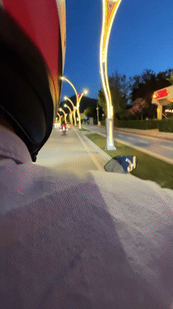 Motorcyclist rides decorated road in Fethiye at dusk