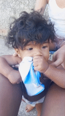 Baby with curly hair observed being comforted with towel