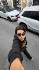 Young man films selfie video while walking Tel Aviv street