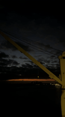 Yellow maritime crane observed against dark sky April 15