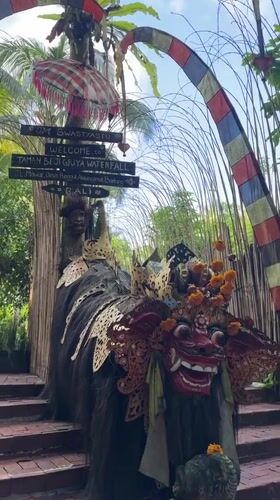 Tourist documents daily life at Bali waterfall destination
