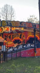 Evening carnival rides illuminate Perm amusement park at sunset