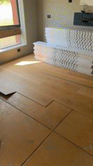 Construction worker installs laminate flooring in Puebla home renovation