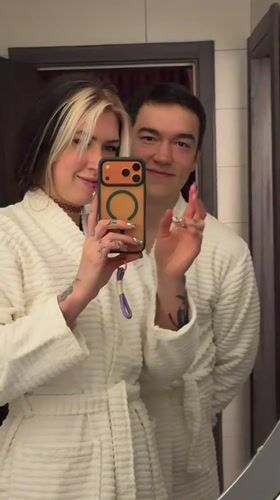 Couple takes playful bathroom selfies in white robes, Serbia