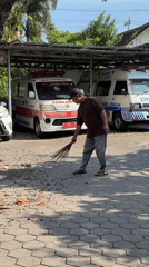 Man sweeps paved area in sunny Kebonsari morning