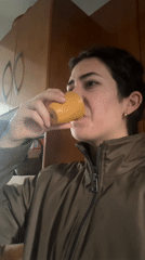 Woman drinks from orange mug indoors in Puebla