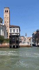 Gliding through a Venice canal past a vaporetto stop