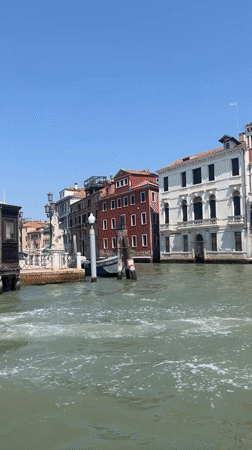 Gliding through a Venice canal past a vaporetto stop