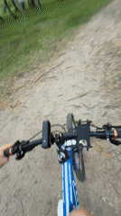 Cyclist rides blue mountain bike through forest path in Tyumen
