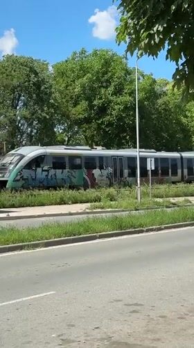 Graffiti-covered train stands still beside road in Lovech, Bulgaria