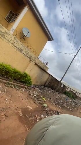 Motorcyclist travels dirt road amid litter in Nigeria