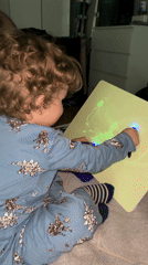 Child plays with glowing drawing board in Klin bedroom