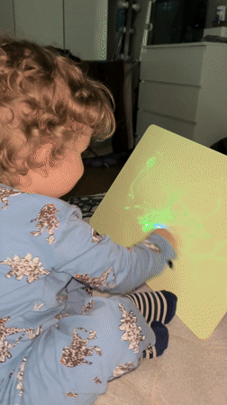 Child plays with glowing drawing board in Klin bedroom