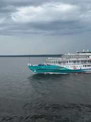River cruise ship passes on the Kama, watched from a nearby boat