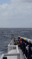Ship travels through rough seas under overcast skies