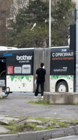 Pedestrian crosses busy Sofia street during afternoon traffic