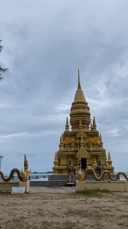 Golden Buddhist pagoda with dragon statuary observed in Thailand