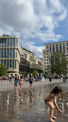 Children play in London fountain during afternoon