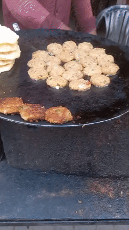 Street vendor prepares food on griddle in Kalpi