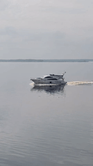 White yacht crosses calm waters near Petrakovo, Russia