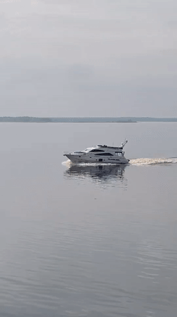 White yacht crosses calm waters near Petrakovo, Russia