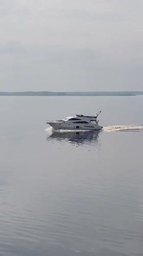 White yacht crosses calm waters near Petrakovo, Russia